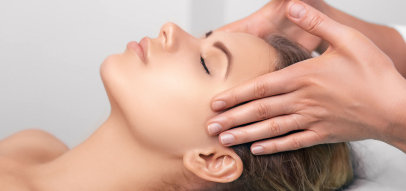 A person receiving a relaxing scalp massage on a table, with soft lighting and a focus on gentle hand movements.
